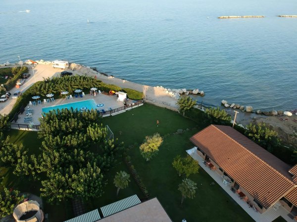 Area piscina vicino al mare con giardino.