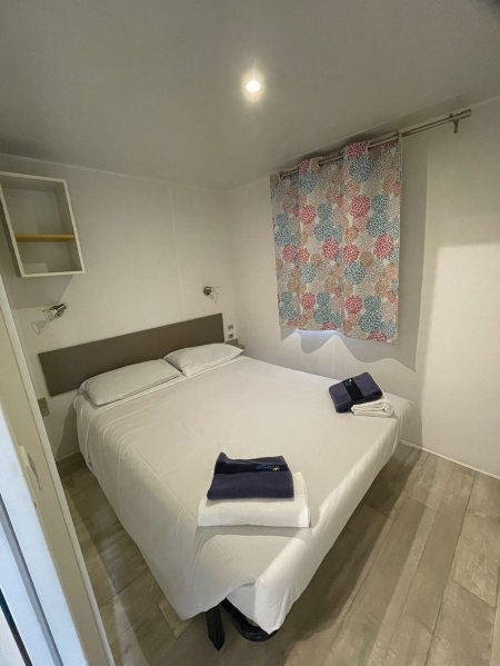 Camera da letto con letto matrimoniale e tende colorate.