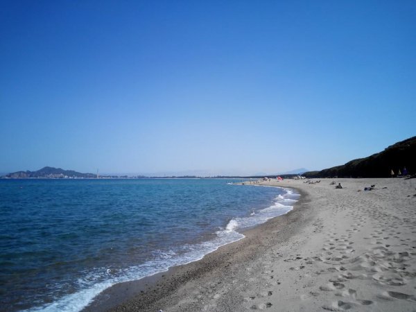 Una spiaggia deserta con sabbia e mare cristallino.