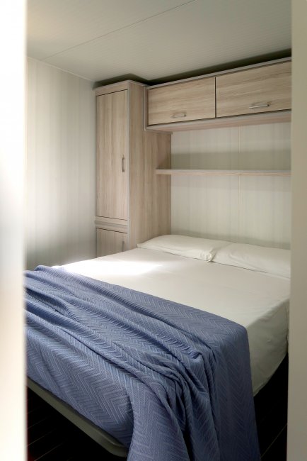 Camera con letto matrimoniale e coperta blu.