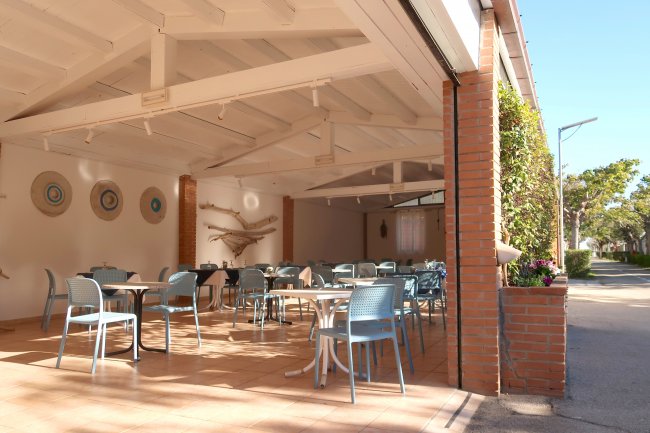 Un ristorante all'aperto con tavoli e sedie azzurre.