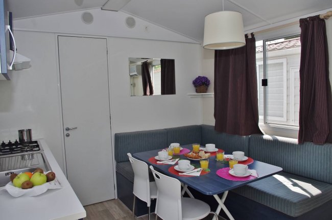 Interno di una casa con tavolo apparecchiato e divano ad angolo.