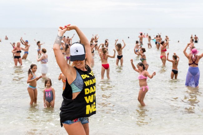 Persone ballano in mare poco profondo.