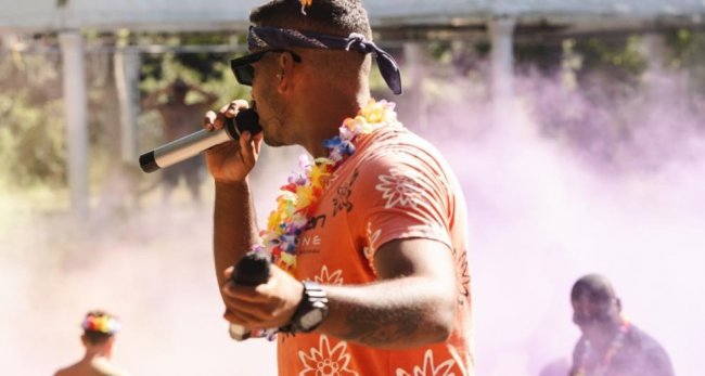 Cantante con microfono e bandana, sfondo sfumato.