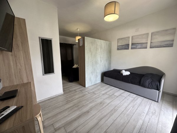 Camera con divano letto e decorazioni murali.