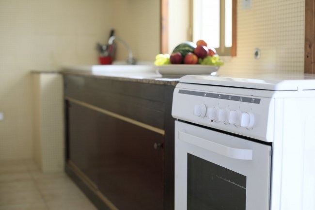 Cucina con forno bianco e frutta sul piano di lavoro.