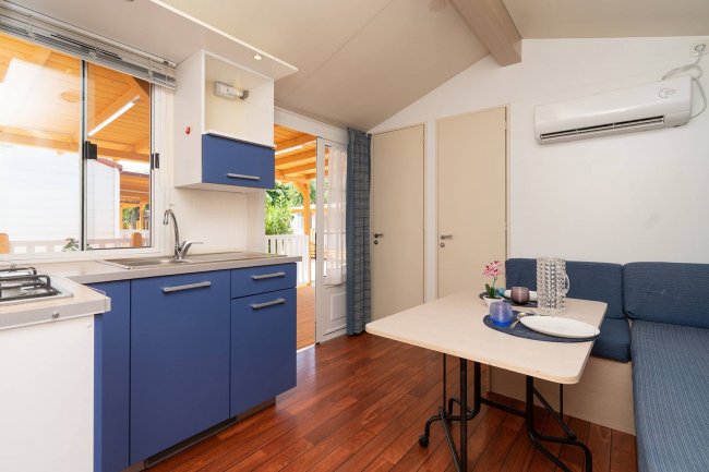 Angolo cottura con tavolo e divano blu.