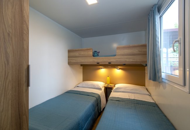 Camera con letti singoli e letto a castello in legno.