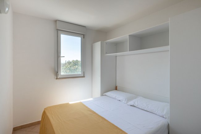 Camera da letto con letto matrimoniale e finestra.