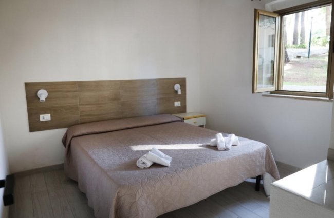 Camera da letto con letto matrimoniale vicino a una finestra.