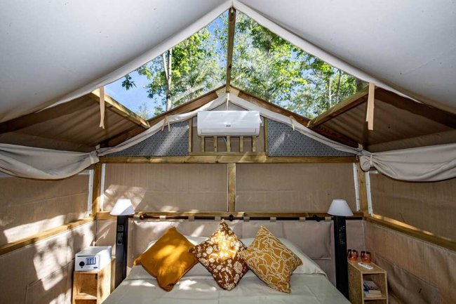 Interno di una tenda glamping con letto.