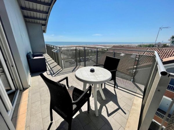 Balcone con sedie e tavolo vista mare.
