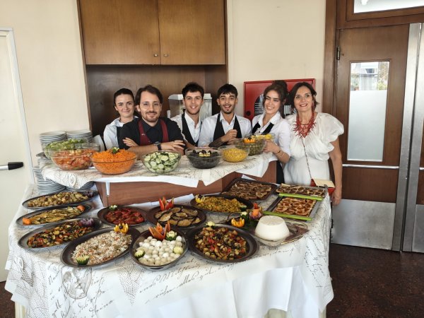 Gruppo di persone dietro un buffet di cibo.