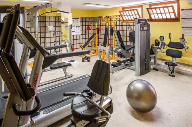 Palestra con attrezzi e una palla fitness.