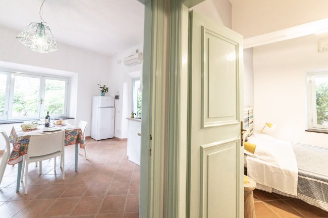 Sala da pranzo e camera con porta aperta.