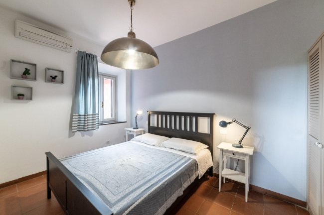 Camera con letto matrimoniale e lampada.