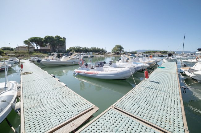 Pontili galleggianti con gommoni ormeggiati in un porticciolo.