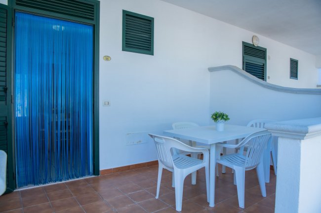 Tavolo bianco e sedie su terrazza.