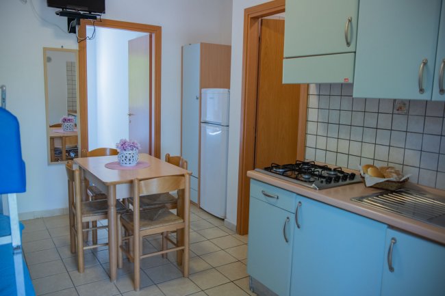 Cucina e sala da pranzo con tavolo e sedie.