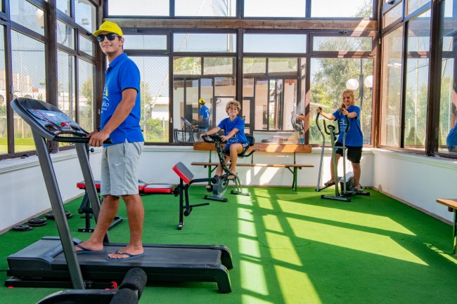 Persone in palestra usano tapis roulant e cyclette.