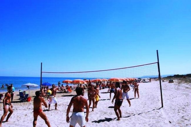 Partita di beach volley su una spiaggia soleggiata.