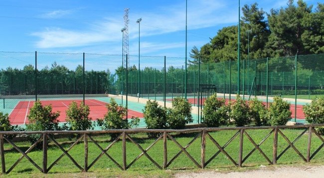 Campi da tennis vuoti circondati da recinzione.