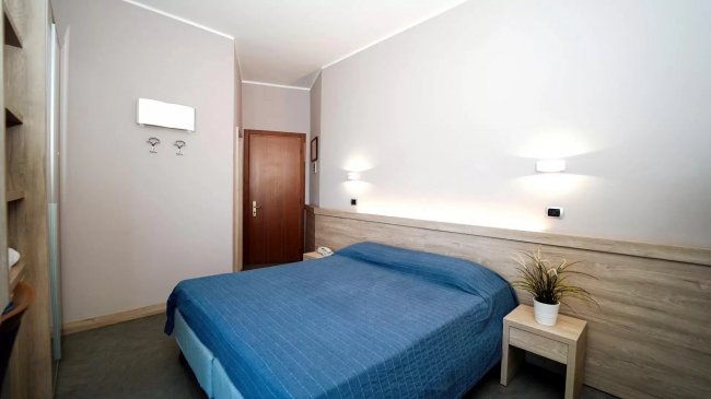 Camera da letto con coperta blu.