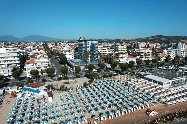 Ombrelloni azzurri su spiaggia.