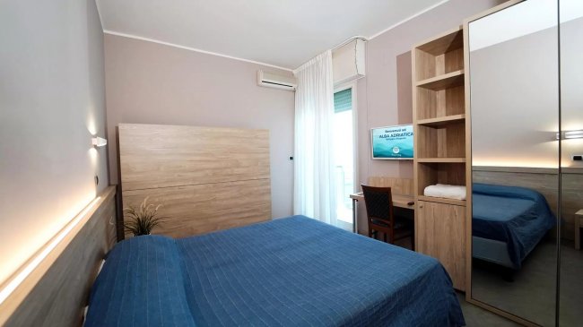 Stanza d'hotel con letto matrimoniale e scrivania.