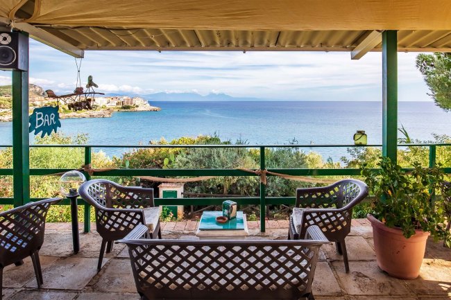 Veranda con sedie e tavolo vista mare.