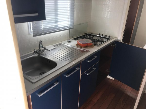 Cucina stretta con fornelli e lavello.