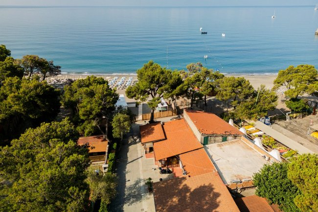 Veduta aerea su case con tetti rossi vicino alla spiaggia.