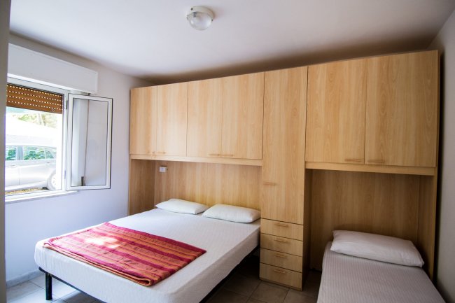 Camera con letto matrimoniale e singolo, armadio a muro.