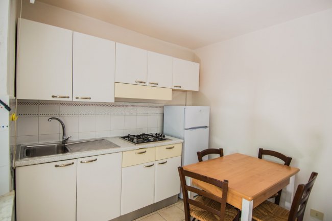 Cucina con tavolo di legno e sedie.