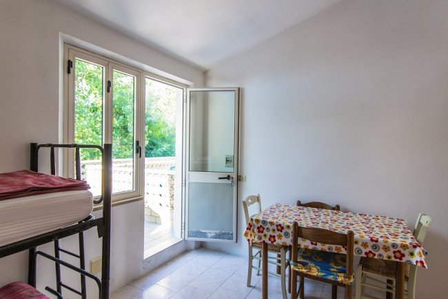 Stanza con tavolo colorato e letto a castello.