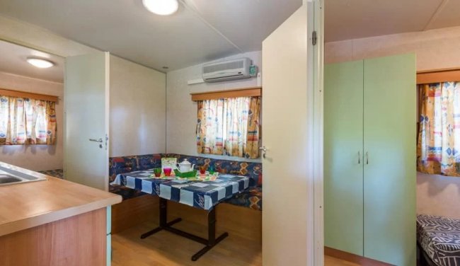 Interno di una casa mobile con tavolo apparecchiato.