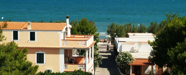 Case vicino al mare con tetti arancioni.