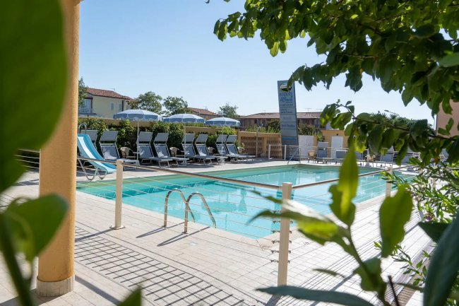 Piscina con lettini e ombrelloni grigi.