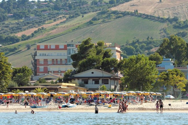 Spiaggia affollata con ombrelloni e mare.