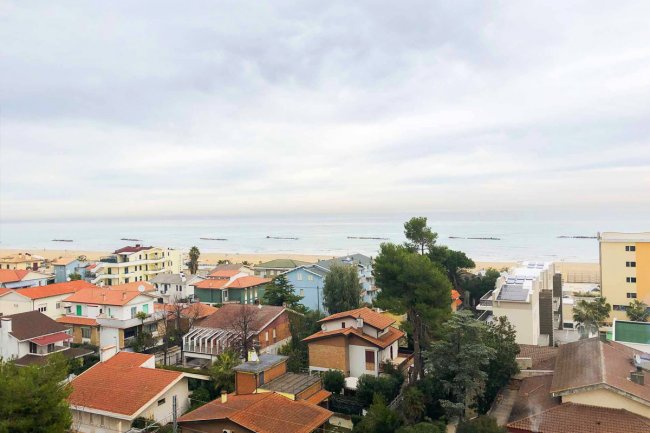 Vista panoramica di una città costiera con case e mare.