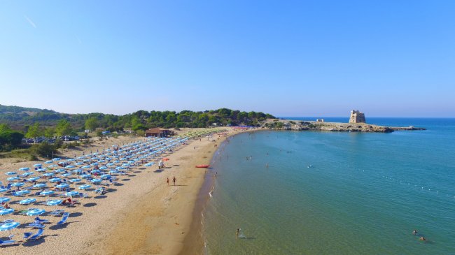 Panoramica di spiaggia, mare e torre storica.
