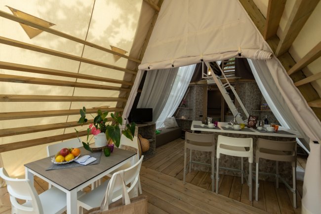 Sala da pranzo all'aperto con frutta su tavolo e pianta decorativa.