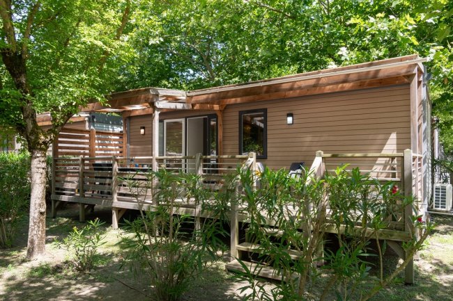 Casa mobile in legno con veranda e giardino.