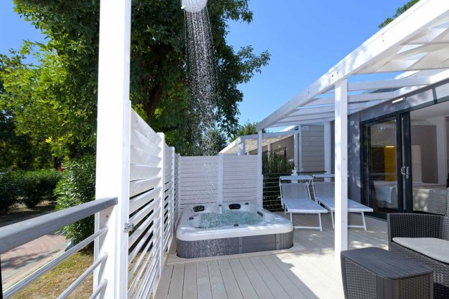Area esterna con vasca idromassaggio e doccia.
