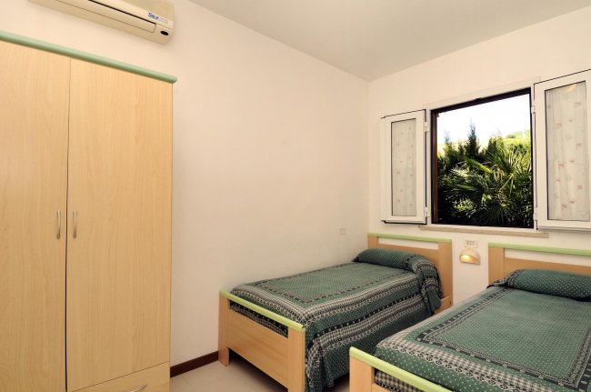 Camera con due letti singoli e armadio.