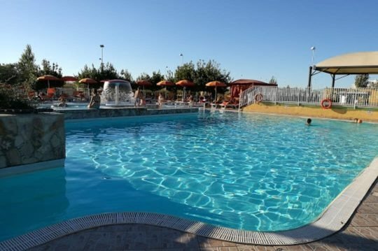 Piscina con ombrelloni arancioni e fontana.