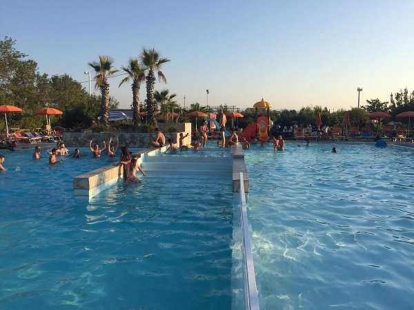 Persone che nuotano in piscina all'aperto.