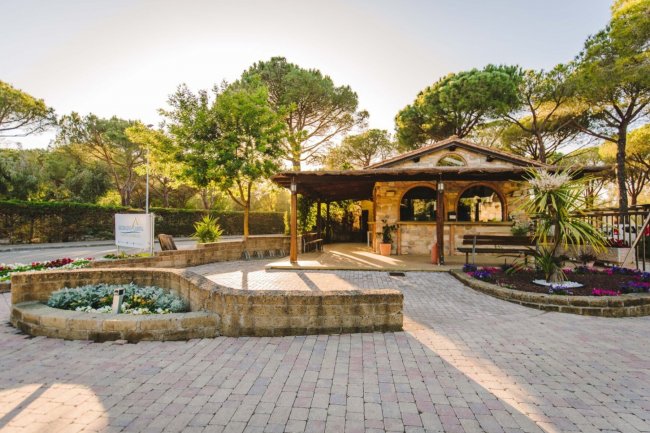 Edificio rustico in un giardino al tramonto.