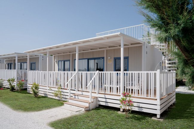 Cabina bianca con veranda e giardino.