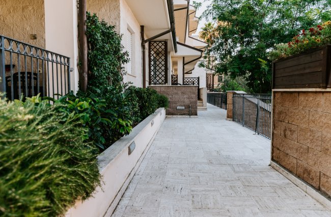 Vialetto esterno con piante verdi.